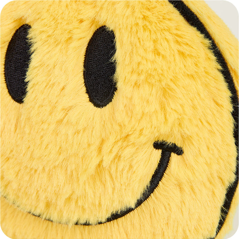 Close-up detail of yellow plush smiley face showing embroidered black eyes and smile