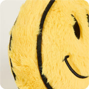 Close-up detail of yellow plush smiley face showing embroidered smile and fuzzy texture