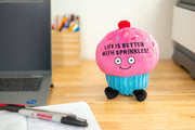 Pink plush cupcake with sprinkles and text 'Life is Better with Sprinkles' on office desk