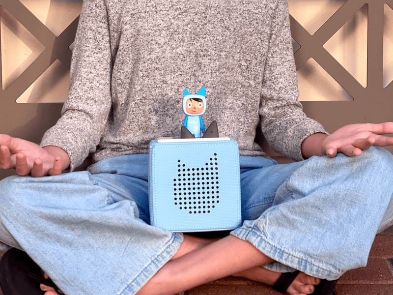 Blue Toniebox with Creative Tonie figure shown in child's lap during use