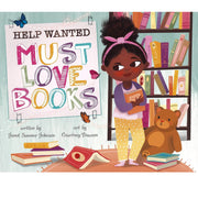 Children's book cover titled 'Help Wanted: Must Love Books' showing an illustrated girl with dark skin holding a book, standing beside a teddy bear and surrounded by books on a shelf and floor.