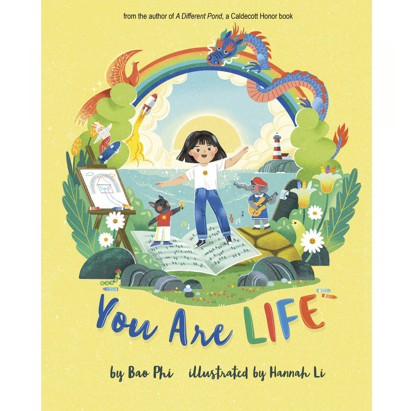 Children's book cover titled "You Are LIFE" by Bao Phi, illustrated by Hannah Li. The cover features a bright yellow background with a colorful central illustration of a child standing on an open book under a rainbow, with dragons, plants, and other whimsical elements.