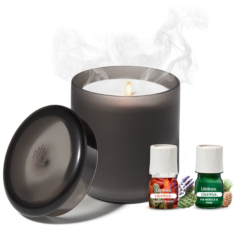 Charcoal flameless candle diffuser with lid and essential oil bottles on white background