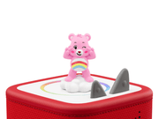 Pink Care Bears Cheer Bear Tonie figurine sitting on red Toniebox with rainbow design