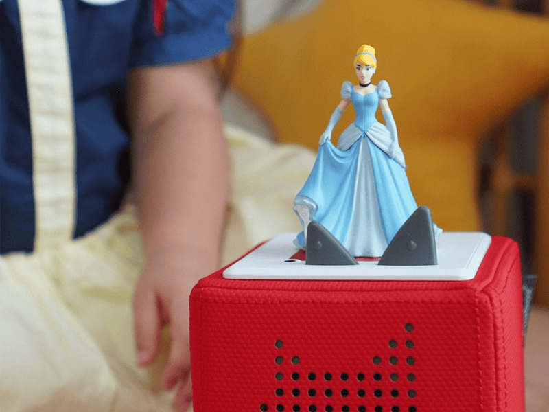 Cinderella Tonie figurine displayed on red Toniebox speaker with child's hand reaching nearby