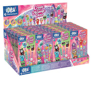 A retail display box filled with multiple pink and purple packages of iDEA Clementoni 'Create Your Message Pens'. The packaging features colorful cartoon characters and message-pen illustrations, set against a clean white background.