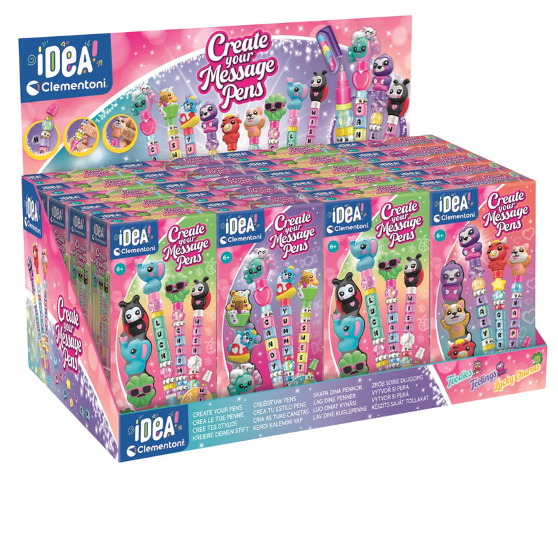 A retail display box filled with multiple pink and purple packages of iDEA Clementoni 'Create Your Message Pens'. The packaging features colorful cartoon characters and message-pen illustrations, set against a clean white background.