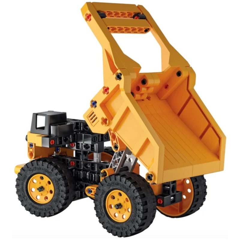 A toy construction vehicle made from interlocking building blocks, featuring a yellow dump truck body with a raised bed, black wheels, and a black cab, shown on a plain white background.