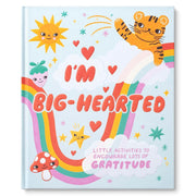 A children's activity book titled 'I'M BIG-HEARTED' with a whimsical pastel cover featuring a smiling tiger, rainbow, sun, mushroom, stars, and hearts on a light blue background.