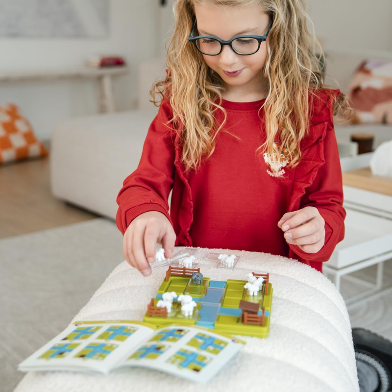 Child playing Counting Sheep and working with guidebook provided in the box in a living room.