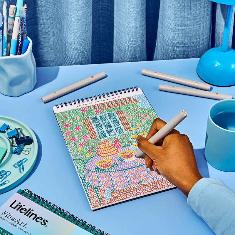 Hand working on Lifelines FlowArt dot-by-letter cozy cottage design with colorful dot pattern