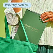 Person holding green Lifelines FlowArt notebook with 'Perfectly portable' text overlay