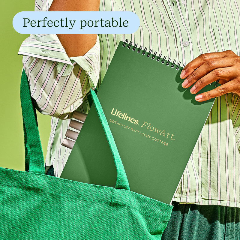 Person holding green Lifelines FlowArt notebook with 'Perfectly portable' text overlay