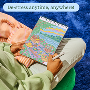 Person relaxing outdoors doing FlowArt dot-by-letter cozy cottage puzzle with colorful dotted scene