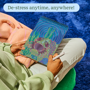 Person using FlowArt dot-by-letter coloring book with colorful dotted pattern design in relaxed setting