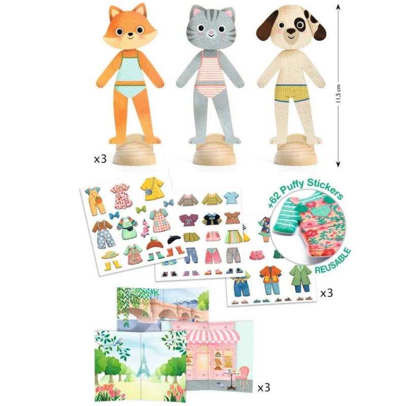 A children's dress-up toy set shown on a white background, including three animal figures (fox, cat, dog) on wooden stands, several sticker sheets with clothing and accessories, a round of colorful puffy stickers, and three Paris-themed playsets. A vertical height marker reads 11.