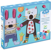 A children's craft kit box featuring two paper collage animals, a rabbit and a cat, on a bright blue background. The packaging shows included materials such as scissors, glue, beads, and small decorative pieces.