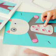 Child's hand interacting with a paper craft of a reindeer on a blue background