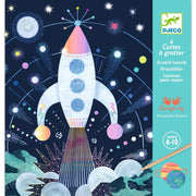 Scratch board with a space-themed design featuring a rocket ship and planets, branded with Djeco.