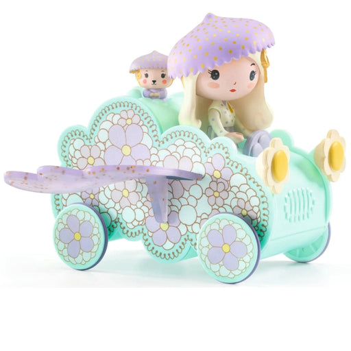 A pastel-colored toy car with a cute doll driver and a small dog figure. The car is mint green with lavender and white floral patterns, yellow flower-shaped headlights, and a lavender umbrella on the driver's head.