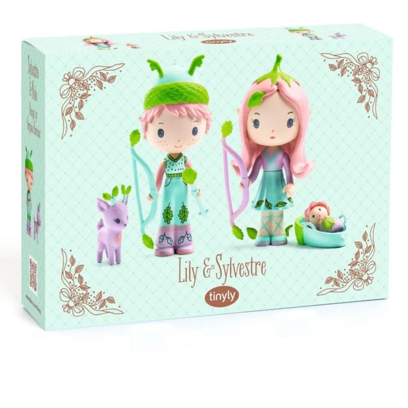 A boxed toy set featuring two cute fantasy children figurines and a small purple animal, shown in its mint-green retail box with floral corner decorations and the text 'Lily & Sylvestre' and 'tinyly'.