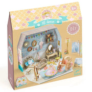 A boxed DIY dollhouse set by Djeco featuring a pastel-colored miniature house with furniture and decorative accessories, shown in its retail packaging on a white background.