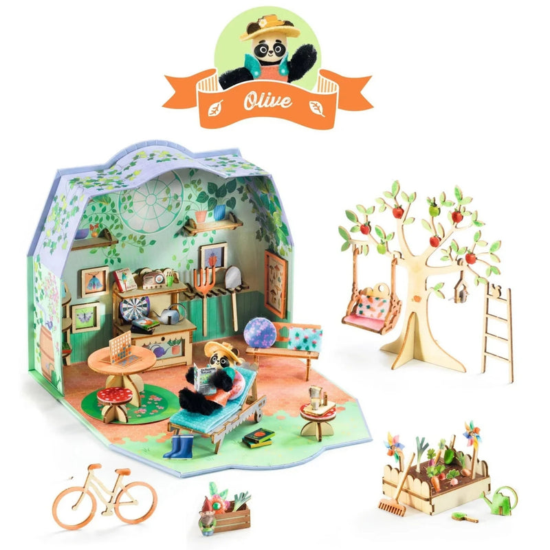 A children's wooden DIY craft kit from Djeco featuring a house, tree, bicycle, and garden elements, displayed on a clean white background with an 'Olive' brand logo at the top.