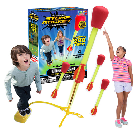 Stomp Rocket toy set with a yellow stand, four foam rockets with red fins and red tops, and a colorful retail box. Two children are shown using the toy on a white background, with one child standing on the yellow stomp platform.