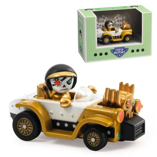 A collectible toy car figure from Camp Motors, featuring a gold and white vintage convertible with a skull-faced driver in a black helmet. The toy is displayed alongside its light green and white retail packaging box on a clean white background.