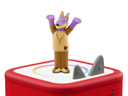 Purple dog character Tonie figure on red Toniebox audio player with shark fins