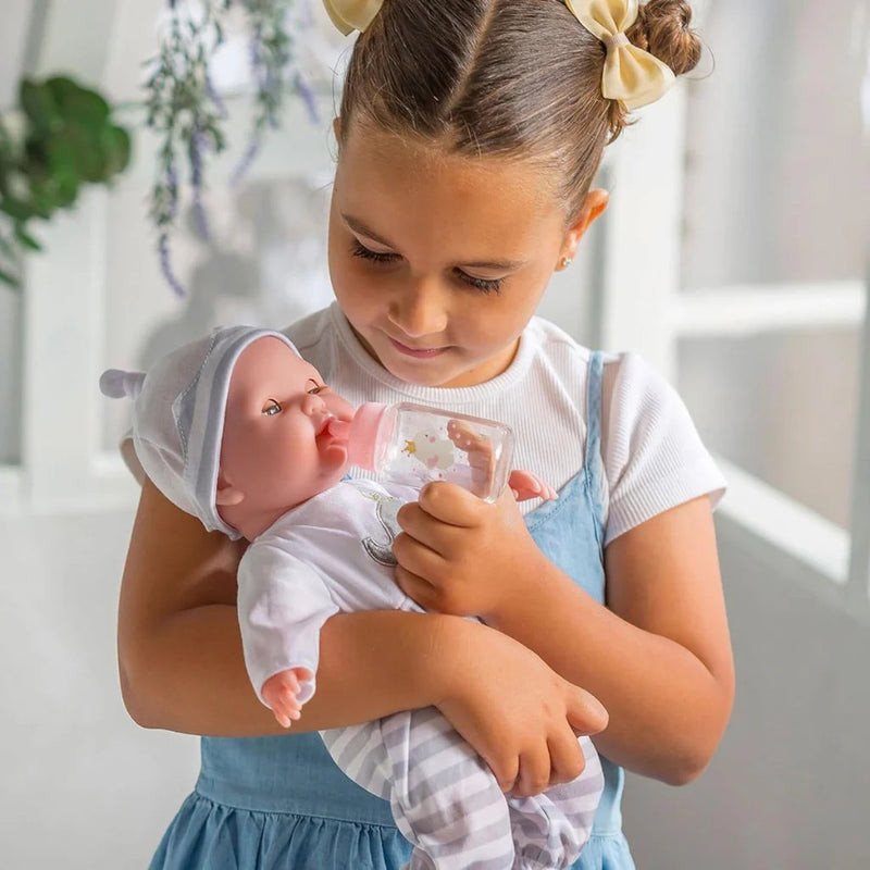Young girl holding a baby doll in a bright indoor setting