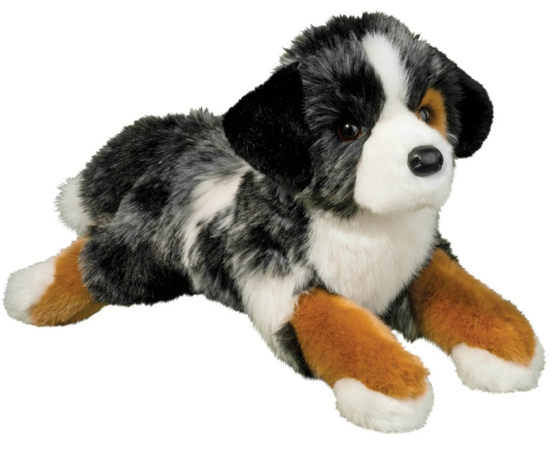 A Dlux plush Australian Shepherd dog stuffed animal toy lying down on a solid white background.