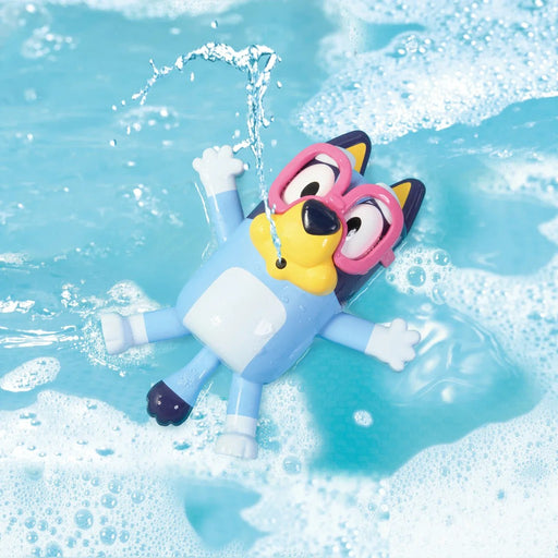Bluey swimming toy figure floating in bubbly blue pool water wearing goggles
