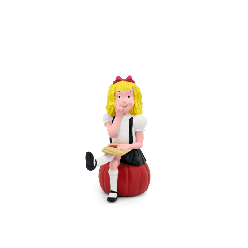 Tonie Eloise figurine with blonde hair, red bow, white dress, sitting on red apple with book