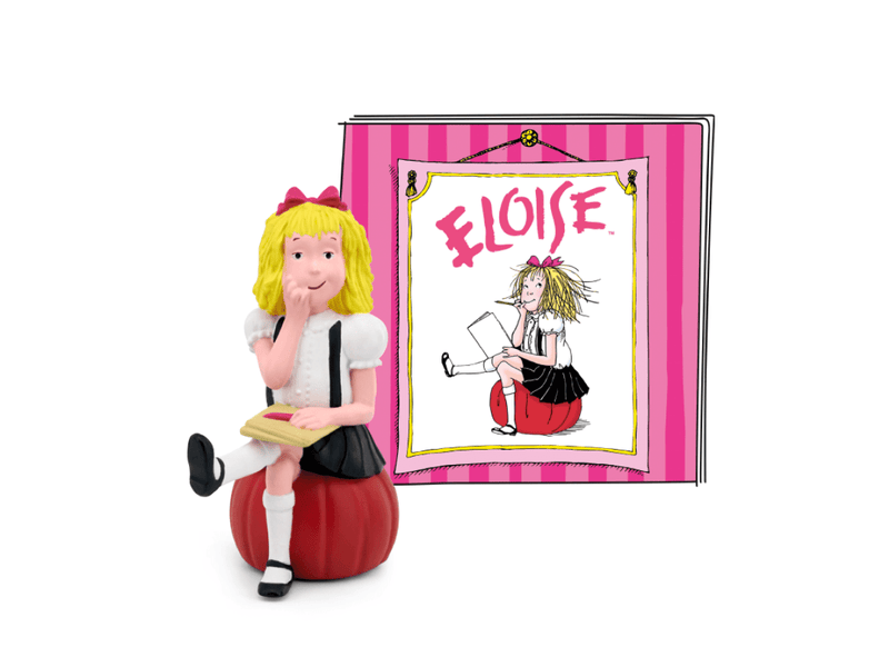 Tonie Eloise figure with blonde hair sitting on red apple next to pink striped book