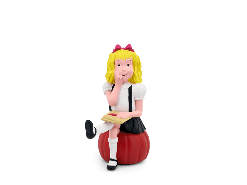Tonie Eloise figurine with blonde hair, red bow, sitting on red apple holding book
