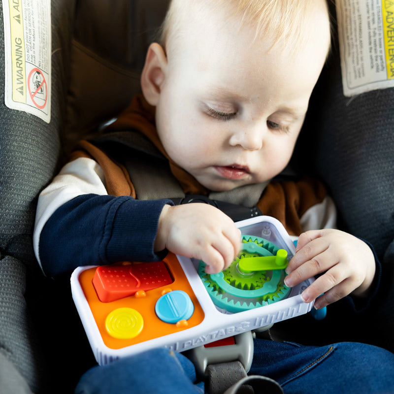 Child playing with the PlayTab Go  in a car seat.