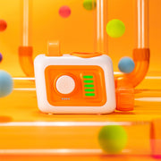 A kid-safe motorized fan unit with a large dial and LED indicators, connected to a colorful, custom-arranged network of modular transparent tubes where lightweight foam balls are suspended and blown through the pathways.