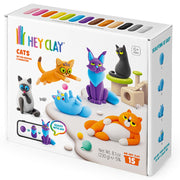 HEY CLAY Cats sculpting and building kit in a white box with colorful cat illustrations and a row of colored clay sticks visible at the top. The box shows multiple cat figures made from the clay, including orange, blue, purple, black, and gray cats.