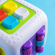 Colorful toy cube with textured buttons on a blue background