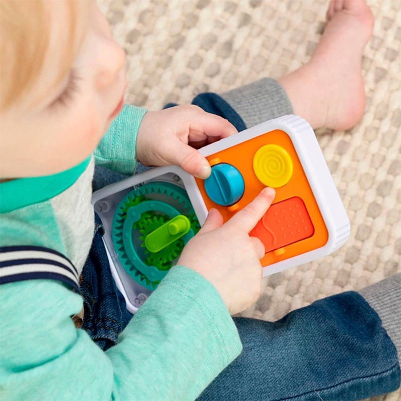 Child playing with PlayTab Go a colorful educational toy on a carpeted floor