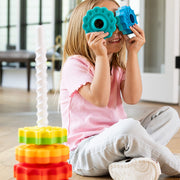 Child playing with SpinAgain's colorful building blocks indoors.