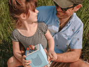 Father and child outdoors with Tonie Box and Finding Nemo character figure
