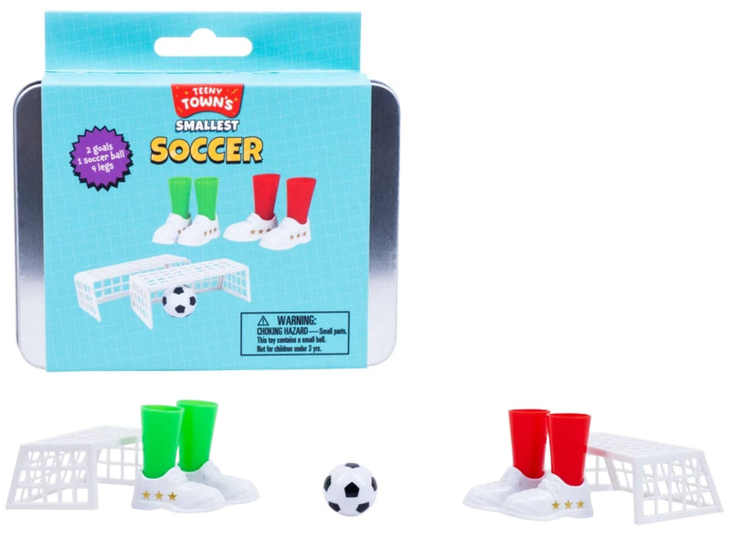 Tiny Town's Smallest Soccer toy set in a silver metal tin with a light blue box, shown alongside the miniature soccer pieces: a small black-and-white ball, white goals, and green and red cups on a white background.