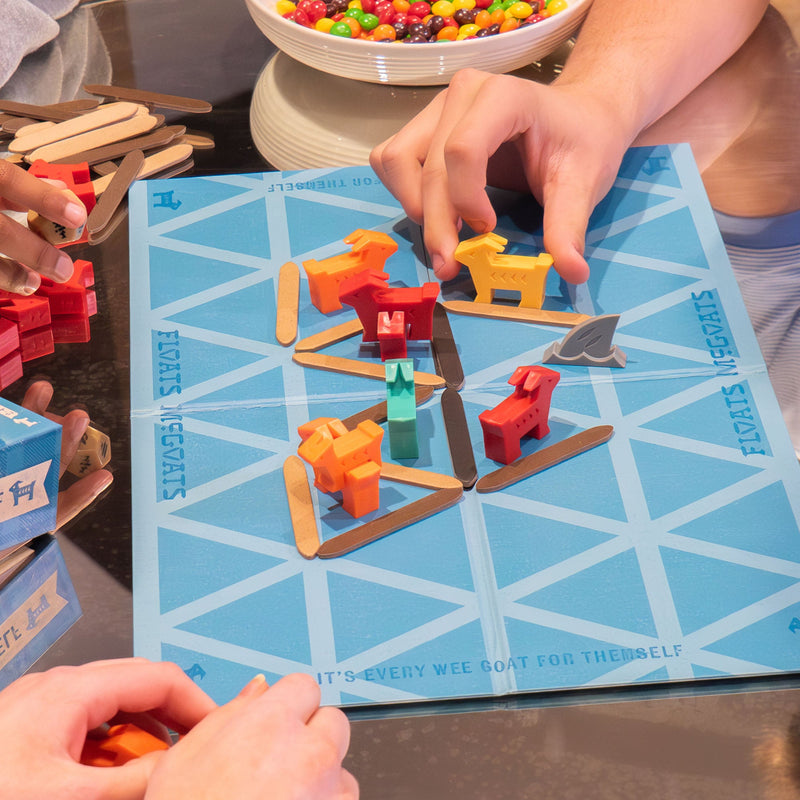 Floats McGoats board game being played with colorful wooden boats on ice board
