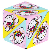 A cube-shaped Hello Kitty folding box with a colorful pastel design featuring Hello Kitty, rainbows, clouds, and pink and light blue panels on a white background.