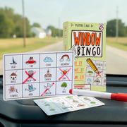 Window Bingo road trip game displayed on car dashboard with bingo cards and markers