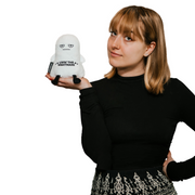 Woman holding white ghost plushie with Livin the Nightmare text and unamused expression