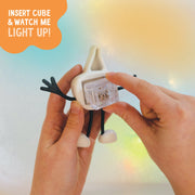 Hands inserting LED cube into white Glo Pals Party Pal character with instruction text overlay