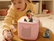 Child playing with pink Toniebox audio player and Gabby's Dollhouse Tonie figures
